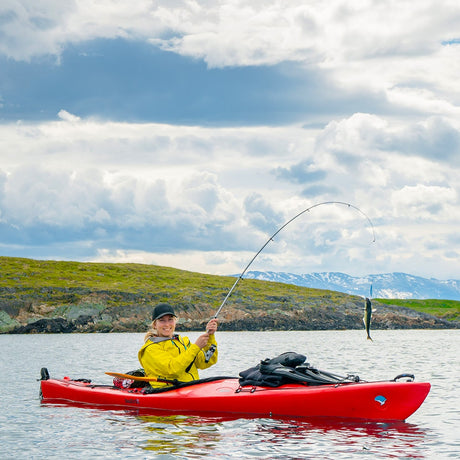Tjej fiskar från kajak – stabil kajak med roder och plats för fritidsfiske