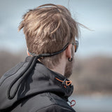 Svart, justerbart flytsnöre från Leech fäst vid solglasögonen på en man. Snöret är utformat för att flyta och förhindra att glasögonen sjunker