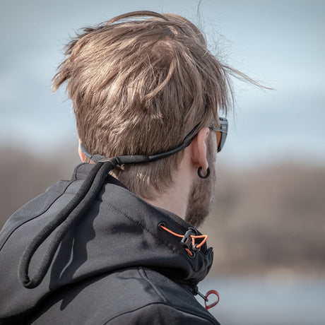 Svart, justerbart flytsnöre från Leech fäst vid solglasögonen på en man. Snöret är utformat för att flyta och förhindra att glasögonen sjunker