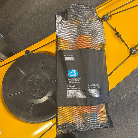 Gul Seabird Expedition kajak med svart lucka. Ett Vidda Basic Safety Kit i svart nätpåse ligger på kajakdäcket