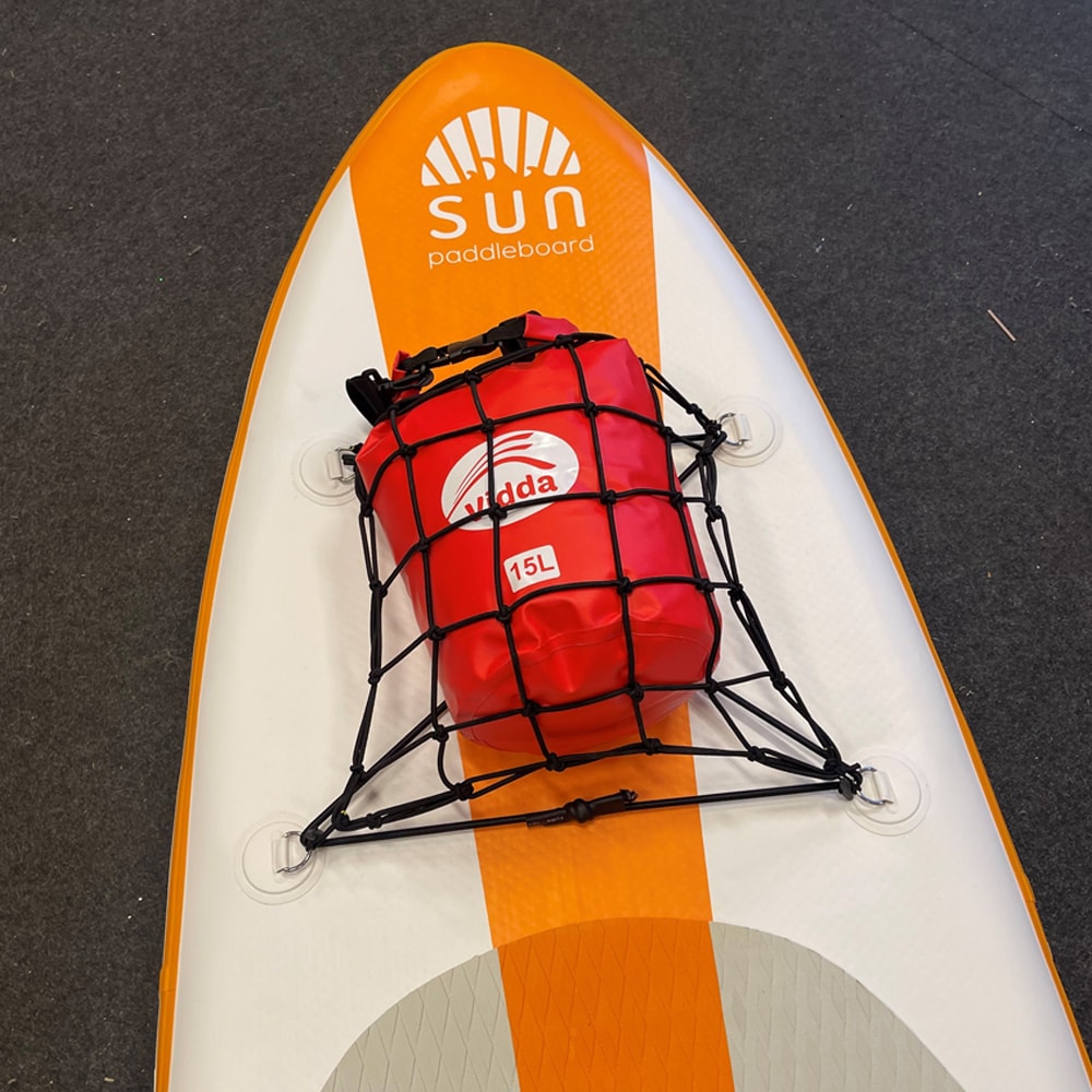 En röd Vidda drybag på 15L säkrad under ett svart lastnät med elastiskt snöre på fören av en vit och orange Sun Paddleboard