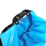 Närbild på stängningen av en ljusblå, vattentät Vidda drybag. Visar svart rulltopp och spänne för tät försegling