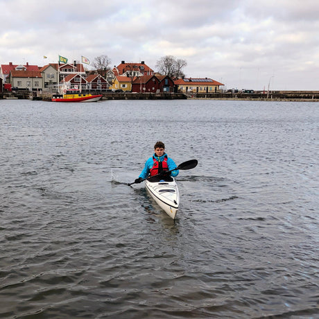 Person paddlar SeaBird Expedition – glasfiberkajak på vattnet